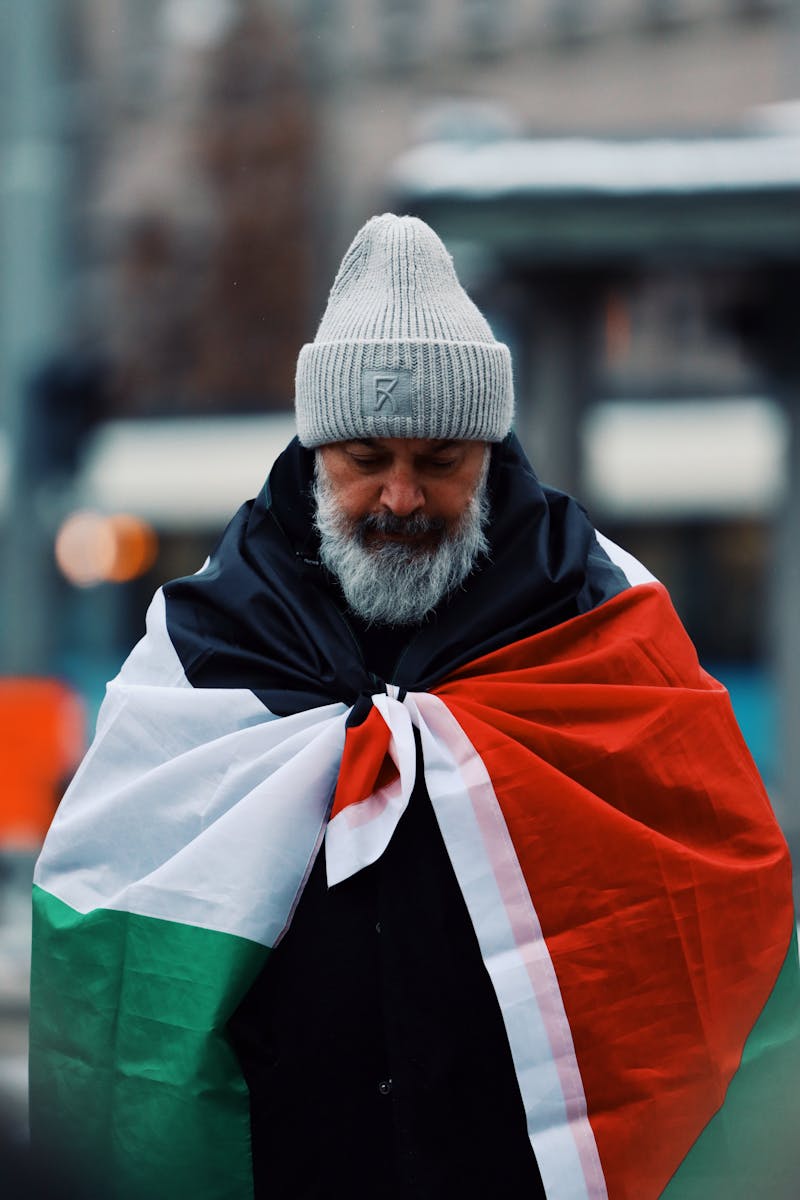 Parliamentary pensions: Man in winter attire draped in a flag during a peaceful protest in Gothenburg, Sweden.