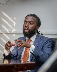 résidus SST: Professional businessman in a suit discussing business strategies in an office setting.