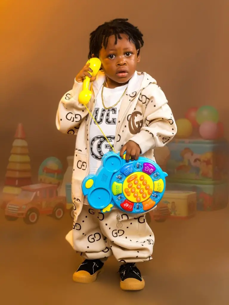 Distribution Jouets: A child plays with a phone toy.