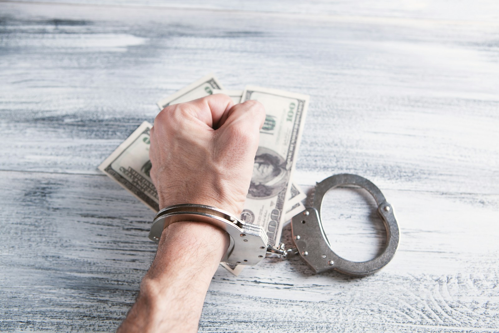 corruption Maurice: person holding silver ring on 100 us dollar bill